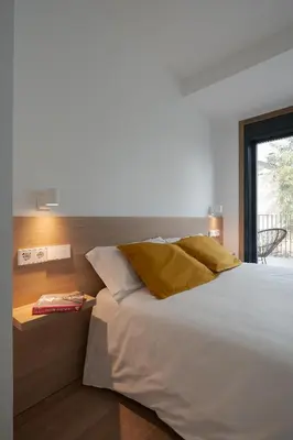 a bedroom with a large white bed and a window at Avós Apartamentos in Monforte de Lemos