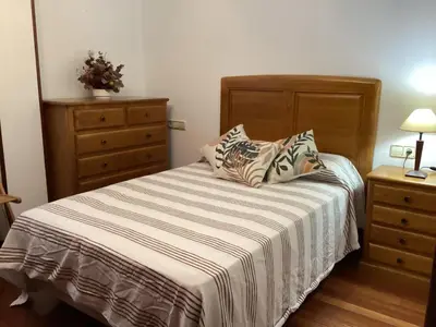 a bedroom with a bed with two pillows and a dresser at Casa Filomena in Santiago de Compostela