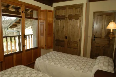 a bedroom with two beds and a window at Alojamiento Rural El atardecer de Sanabria in San Juan de la Cuesta