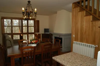 a kitchen and dining room with a table and a fireplace at Alojamiento Rural El atardecer de Sanabria in San Juan de la Cuesta