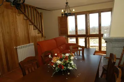 a dining room with a table with flowers on it at Alojamiento Rural El atardecer de Sanabria in San Juan de la Cuesta