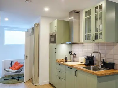 a kitchen with green cabinets and a sink at Alojamientos 