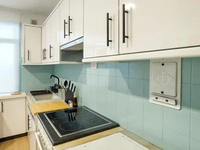 a kitchen with white cabinets and a stove top oven at Alojamientos 