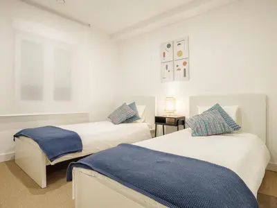 two beds in a room with white walls at Alojamientos 