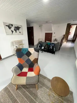 a living room with a couch and a chair at Albergue Amodiño in Arzúa