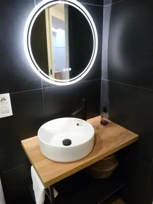 a bathroom with a white sink and a mirror at Foroplaza Duplex in Lugo