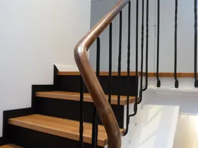 a wooden staircase with black and wooden treads at Foroplaza Duplex in Lugo