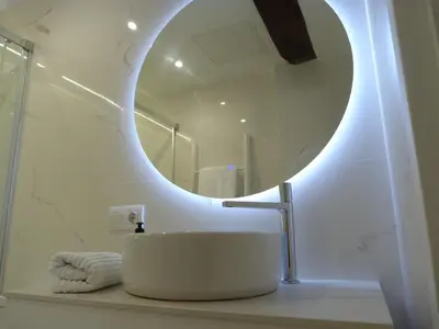 a bathroom with a white sink and a mirror at Foroplaza Duplex in Lugo