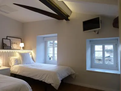 a bedroom with two beds and a flat screen tv at Foroplaza Duplex in Lugo