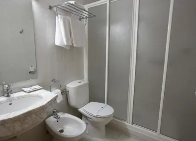 a white bathroom with a toilet and a sink at Nest Style Santiago in Santiago de Compostela