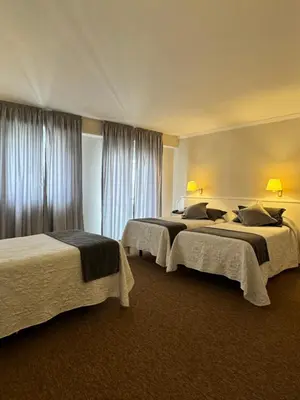 a hotel room with two beds and a window at Nest Style Santiago in Santiago de Compostela