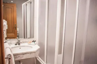 a white bathroom with a sink and a mirror at Nest Style Santiago in Santiago de Compostela