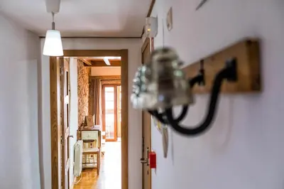 a hallway with a chandelier hanging on a wall at Alda Fogar Natural in Santiago de Compostela