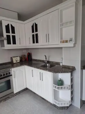 a kitchen with white cabinets and a sink at Ático espacioso en zona céntrica in Sarria