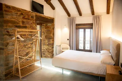 a bedroom with a bed and a stone wall at pension campillo in Fonsagrada