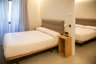a bedroom with two beds and a mirror at pension campillo in Fonsagrada