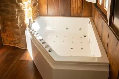 a white bath tub in a room with wooden floors at pension campillo in Fonsagrada