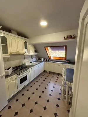 a kitchen with white cabinets and a tile floor at Apartamento 16 in Ribadavia