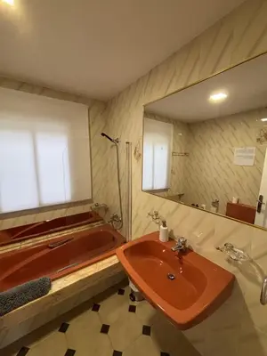 a bathroom with a tub and a sink and a mirror at Apartamento 16 in Ribadavia
