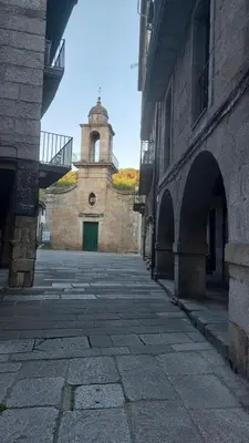 an alley with a building with a clock tower at Apartamento 16 in Ribadavia