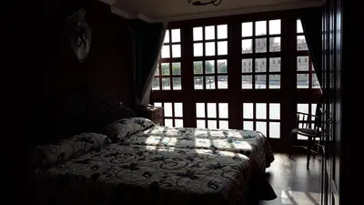 a bedroom with a bed in front of a window at Hostal Medievo in Monforte de Lemos
