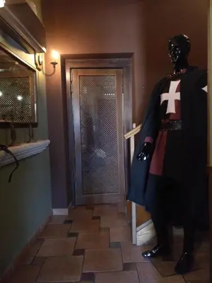 a man in a superhero costume standing in front of a door at Hostal Medievo in Monforte de Lemos