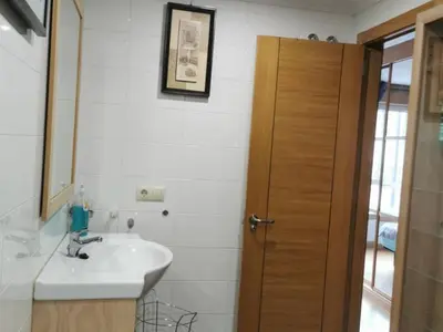 a bathroom with a sink and a mirror at Apartamento con 2 habitaciones y vistas a la Ría del Burgo in Cambre