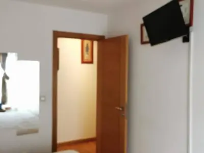 a room with a door and a television on a wall at Apartamento con 2 habitaciones y vistas a la Ría del Burgo in Cambre