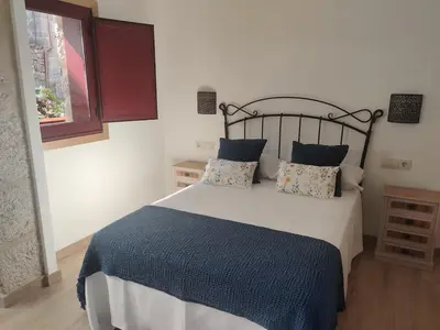 a bedroom with a large bed with a blue blanket at Casa da Ramona in Ribadavia