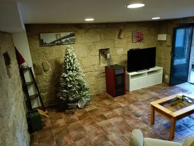 a living room with a christmas tree and a television at A casiña do abuelo Pepe in A Lama