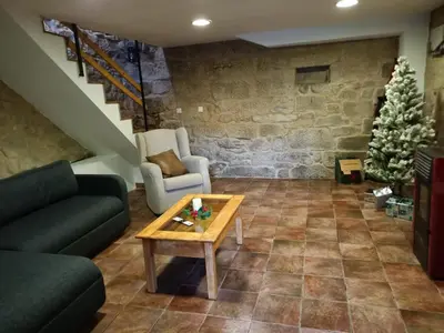 a living room with a couch and a table and a christmas tree at A casiña do abuelo Pepe in A Lama