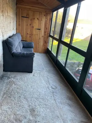 a couch sitting in a room with windows at A casiña do abuelo Pepe in A Lama