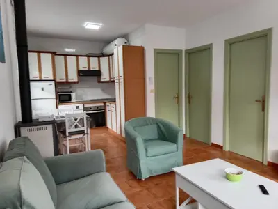 a living room with a couch and chairs and a kitchen at Vila Montecelos in Antas de Ulla