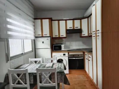 a small kitchen with a table and a refrigerator at Vila Montecelos in Antas de Ulla