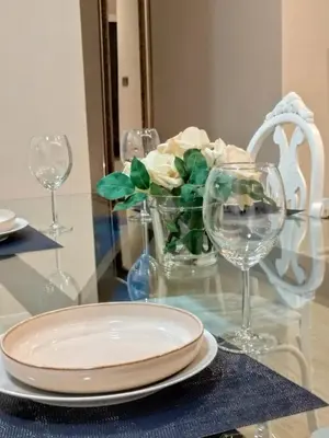 a table with a plate and a vase of flowers and glasses at Mamá Ignacia in Lugo