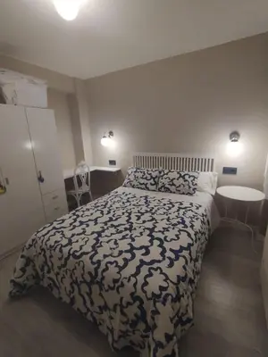 a bedroom with a bed with a black and white comforter at Mamá Ignacia in Lugo