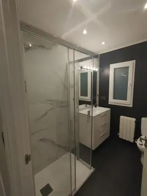 a bathroom with a glass shower and a sink at Mamá Ignacia in Lugo