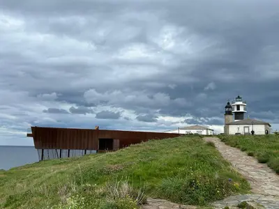 a building on top of a hill with a lighthouse at La Atalaya de Sanci in San Ciprián