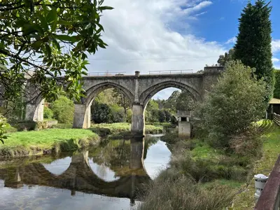 an old stone bridge over a river at La Atalaya de Sanci in San Ciprián