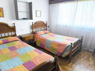 a bedroom with two beds and a window at Gran chalet con jardín, piscina y BBQ in Sada