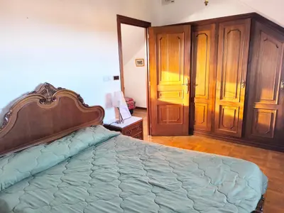 a bedroom with a large bed and wooden cabinets at Gran chalet con jardín, piscina y BBQ in Sada