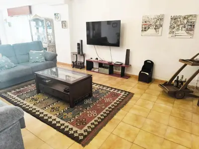 a living room with a couch and a tv at Gran chalet con jardín, piscina y BBQ in Sada