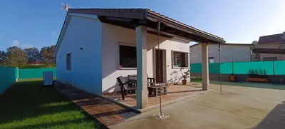 a small house with a porch with a swing at Casa da Braña in Teo