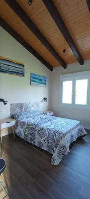 a bedroom with a bed and two windows at Casa da Braña in Teo