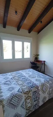 a bedroom with a large bed in a room with windows at Casa da Braña in Teo