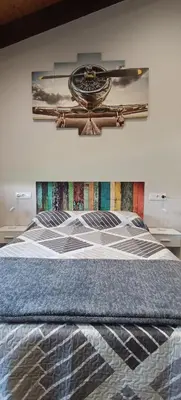 a bedroom with a large bed with a painting on the wall at Casa da Braña in Teo