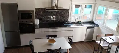 a kitchen with a table and a table and chairs at Casa da Braña in Teo