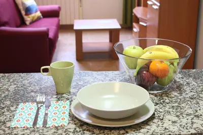 a bowl of fruit sitting on a table with a cup at Apartamentos Turísticos Cancelas by Bossh Hotels in Santiago de Compostela