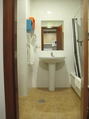 a bathroom with a sink and a mirror at Apartamentos Turísticos Cancelas by Bossh Hotels in Santiago de Compostela