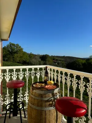 a patio with two stools and a bottle of wine at Casa Pepe in Ourense
